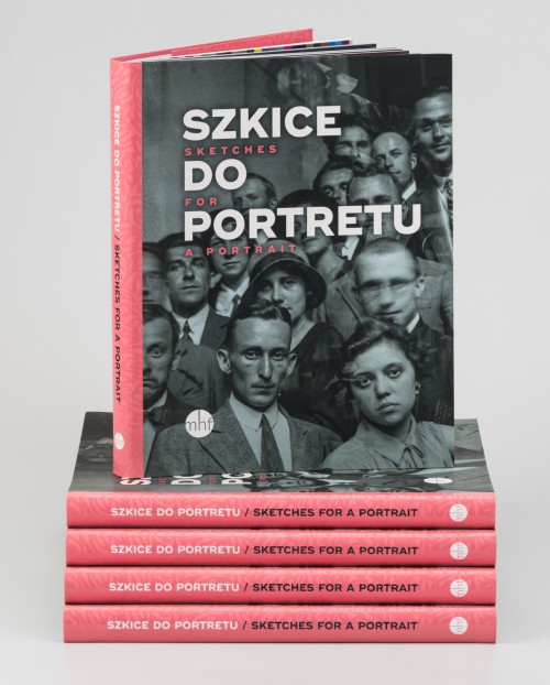 Okładka książki „Szkice do portretu” Książka stojąca na stosie innych książek, na okładce zdjęcie czarno-białe, z początku XX wieku, portret dużej grupy młodych ludzi patrzących w obiektyw