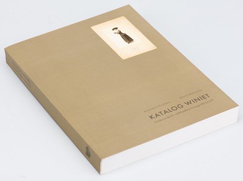 Okładka książki „Katalog winiet” Leżąca książka, na szarej okładce reprodukcja fotografii atelierowej przedstawiającej stojącą z profilu kobietę