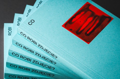 Niebieska okładka książki z czerwonym zdjęciem i tytułem. 