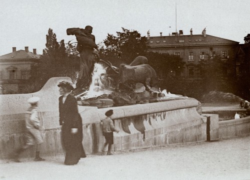 Ludzie spacerujący obok fontanny. 