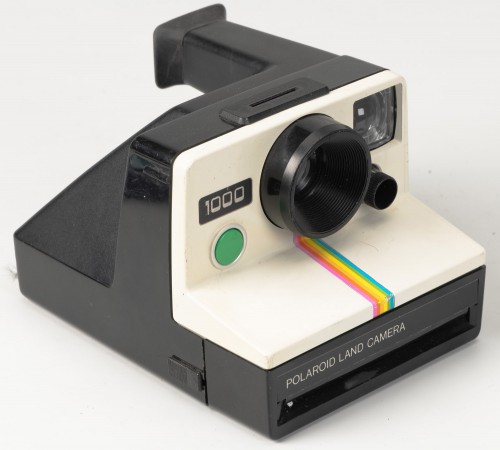 Aparat fotograficzny w czarno-białej obudowie. 