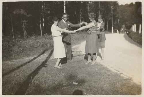 Dwie kobiety i mężczyzna stoją trzymając się za ręce.