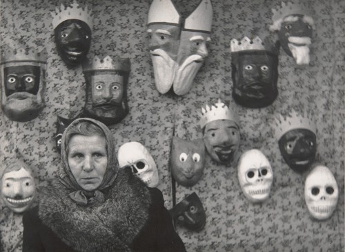 Kobieta wśród masek jasełkowych.