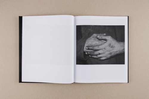 Otwarta książka z fotografią splecionych dłoni. 