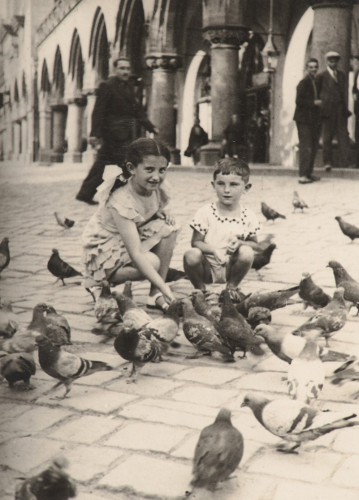Dziewczynka i chłopiec wśród gołębi.
